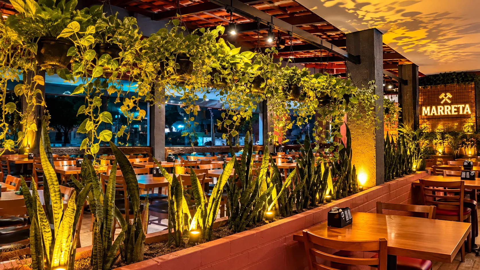 Salão do Marreta Gastrobar com jardim e iluminação acolhedora
